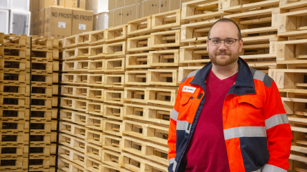 Kimmo Selviranta seisoo kuormalavojen edessä.