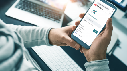 Henkilö käyttää eSchenker-palvelua matkapuhelimellaan.