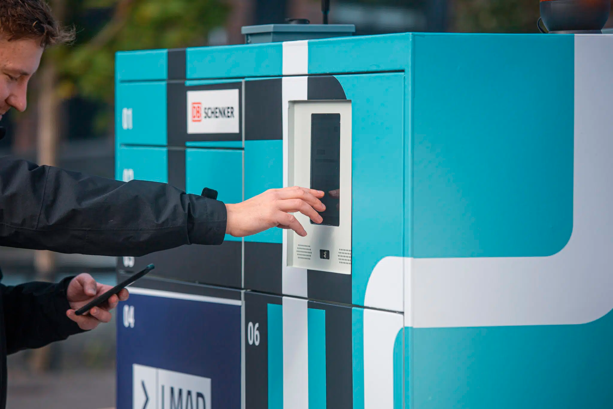 Asiakas noutaa pakettiaan LMAD-jakelurobotin kyydistä