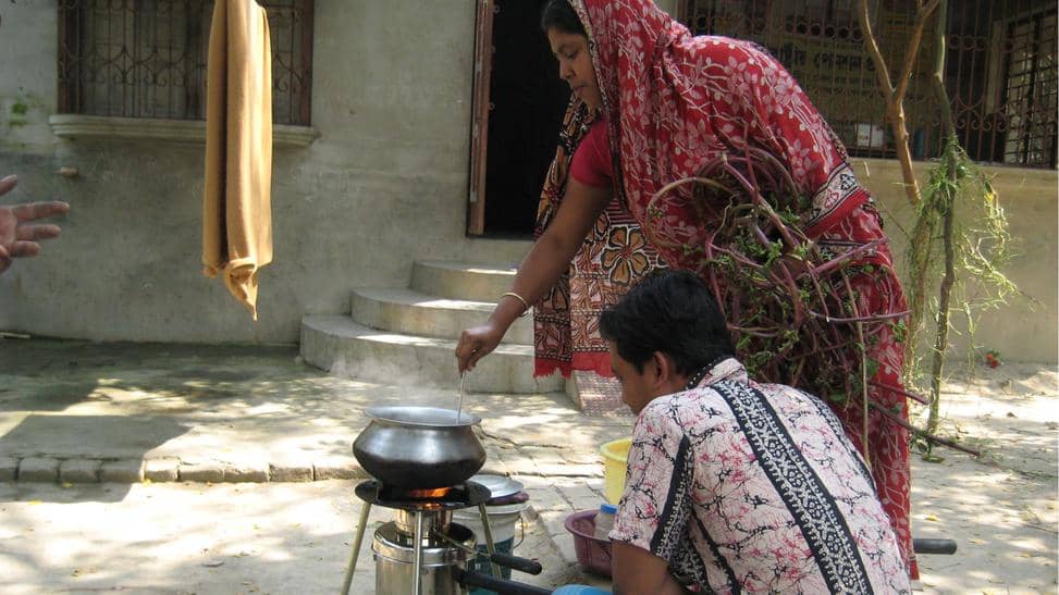 Mies ja nainen käyttävät puukaasukeitintä.