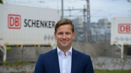 DB Schenkerin merikuljetuksista vastaava johtaja Christian Flatum katsoo kameraan DB Schenkerin konttien edessä.