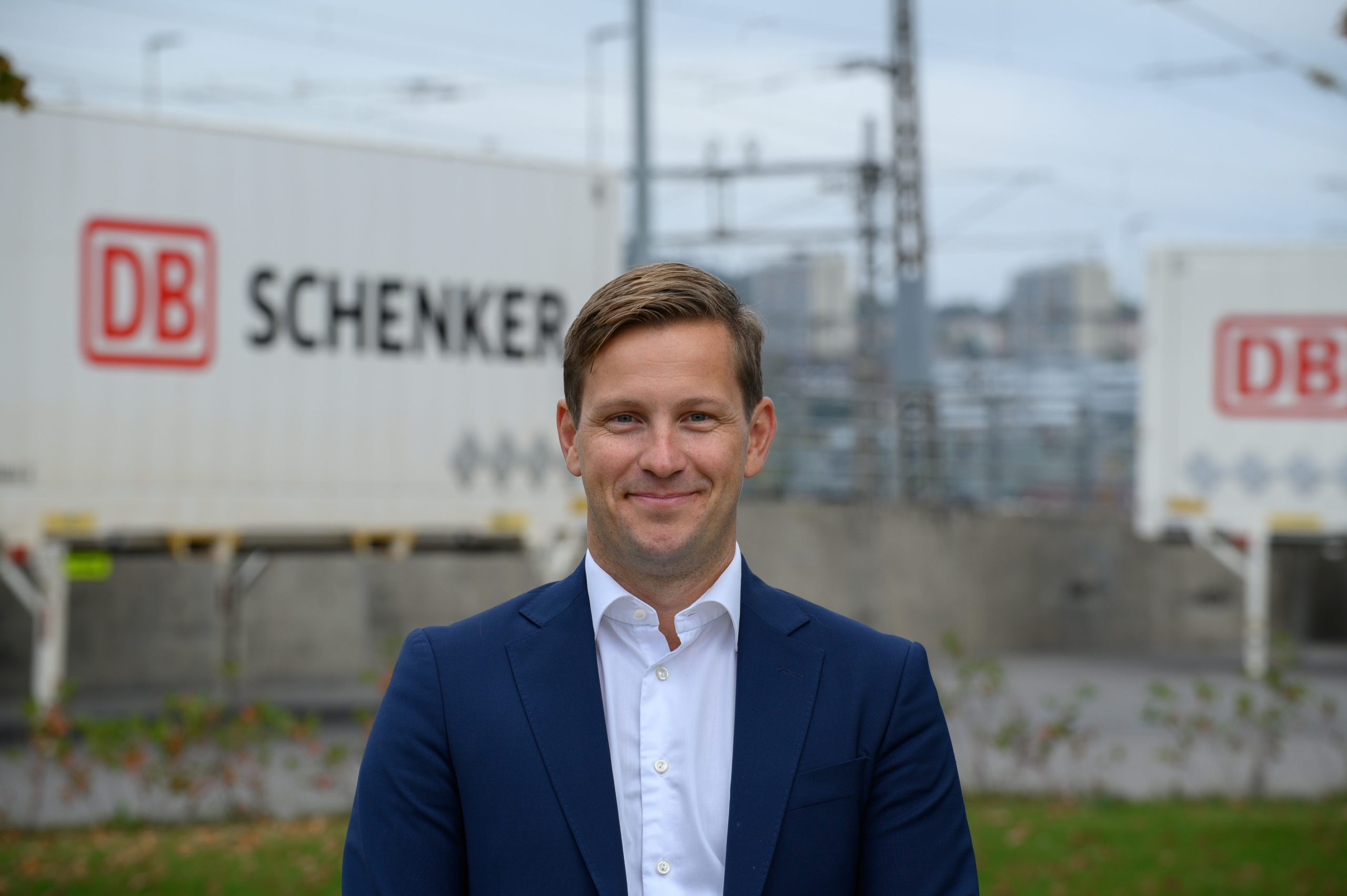 DB Schenkerin merikuljetuksista vastaava johtaja Christian Flatum katsoo kameraan DB Schenkerin konttien edessä.